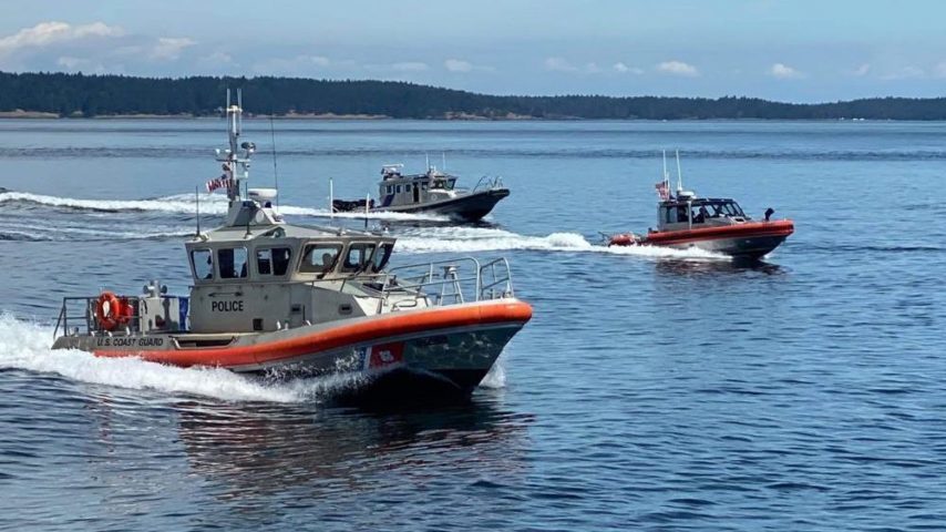 Three small Coast Guard boats conducting exercises at sea