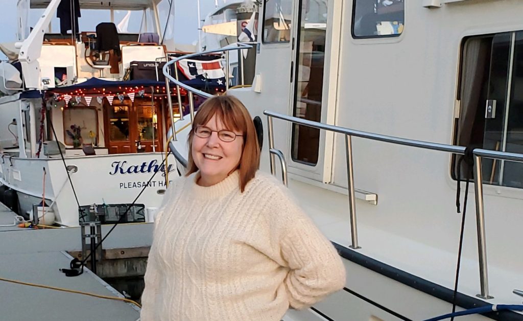 Sue standing in front of her boat