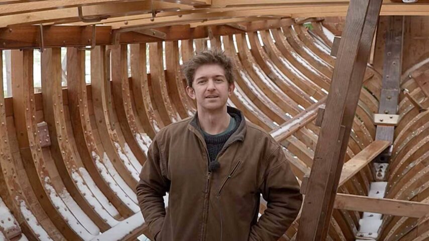 Photo of Leo Goolden standing inside restored ribs of Tally Ho