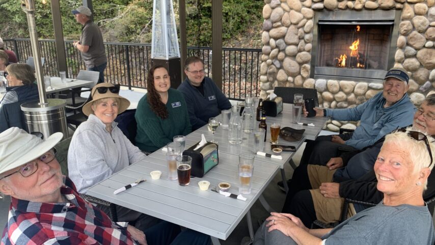 Photo of yacht club members dining on the covered patio in front of the fireplace.