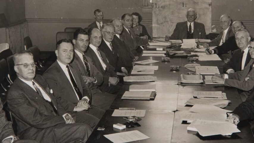 ABYC historic photo of designers sitting at tables with paperwork