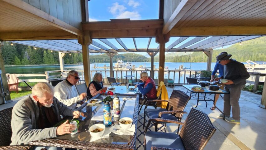 Flotilla group having a potluck under the gazebo structure overlooking the marina docks