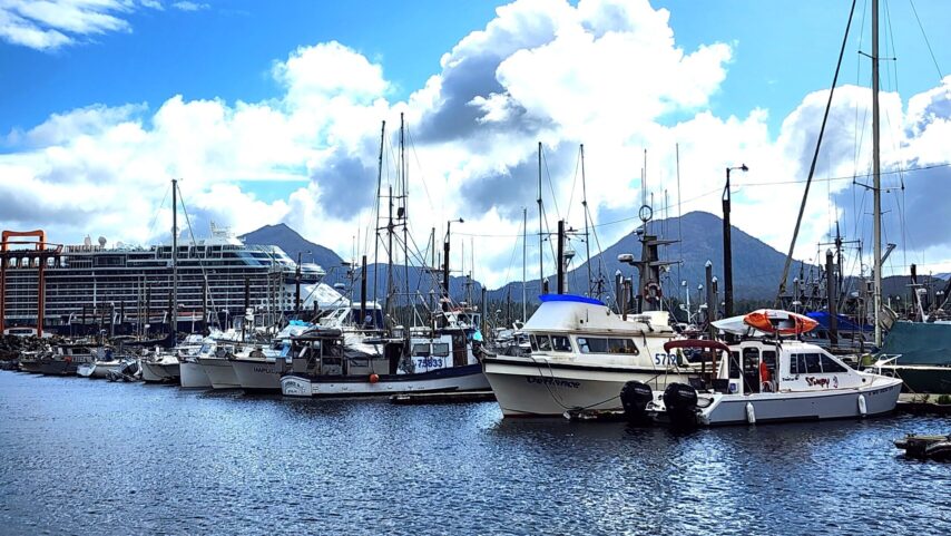 Flotilla boats at the dock in Ketchikan with cruise ship and mountains in the background