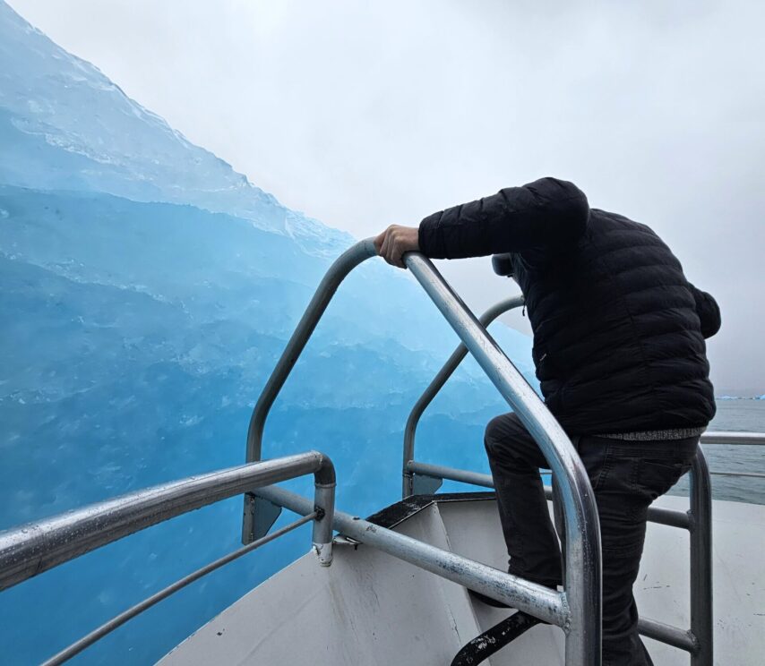 Tour boat edging up close to a large ice berg