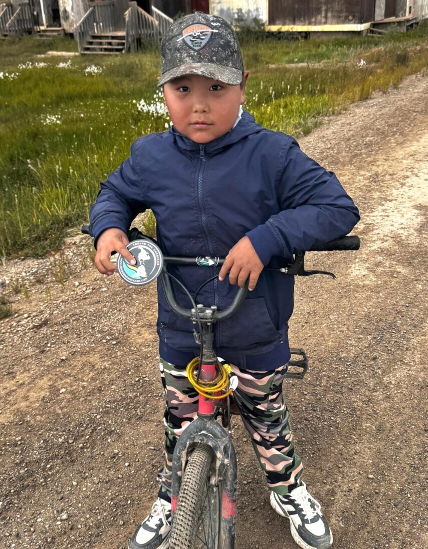 Native boy, Conrad, on bicycle giving a tour of Tuktoyaktuk