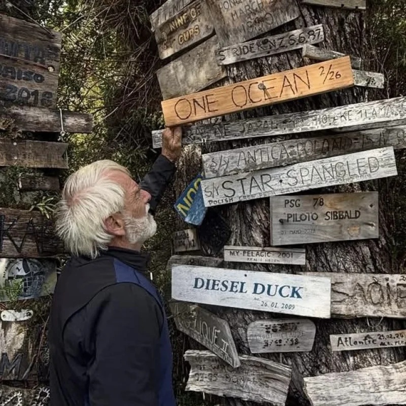 Captain Mark Schrader affixing the s/v One Ocean boat name to a tree in Patagonia