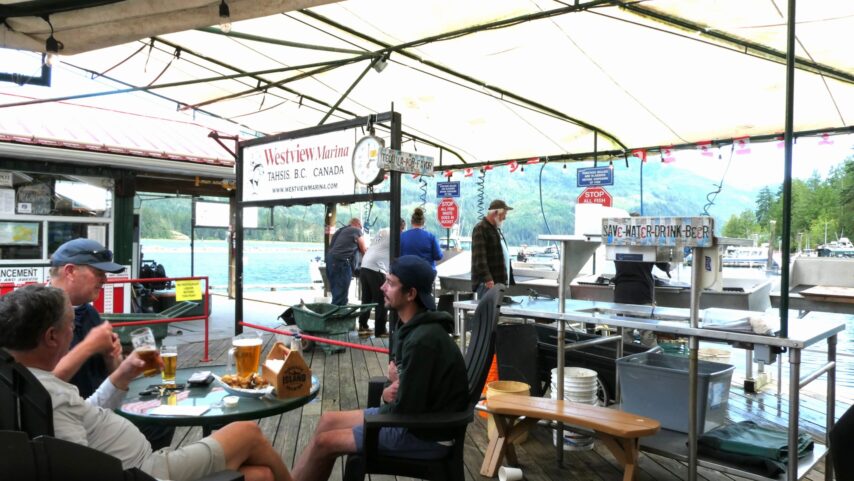 Photo of people enjoying lunch while watching fishermen clean their catch