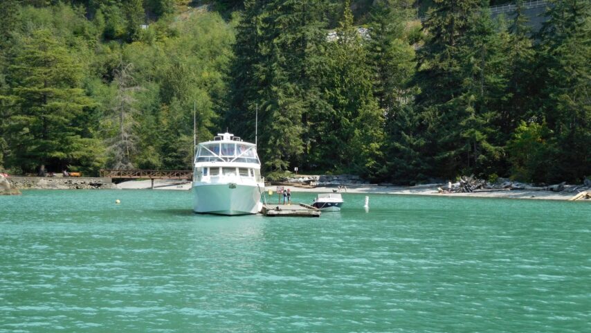 Photo of boat tied to a float with mooring buoy in background at Porteau Cove Park in Howe Sound