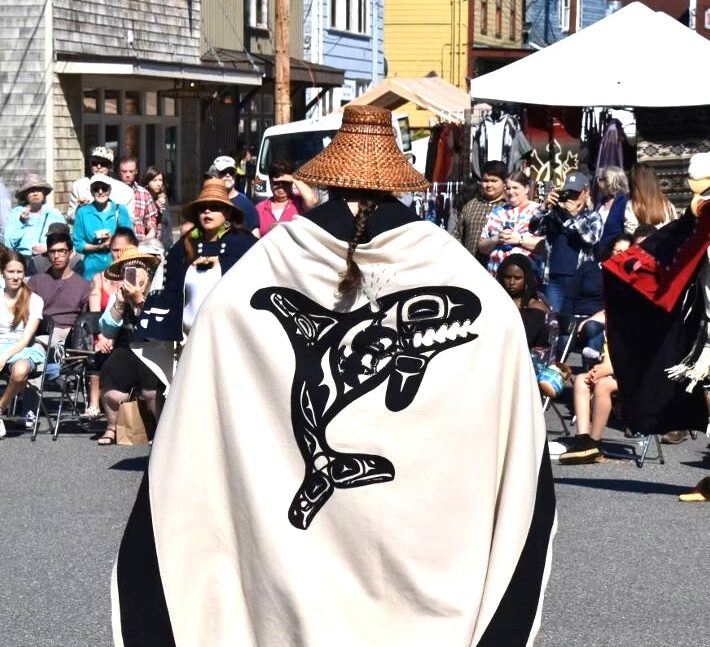 Photo of dancer with Native whale blanket and straw hat